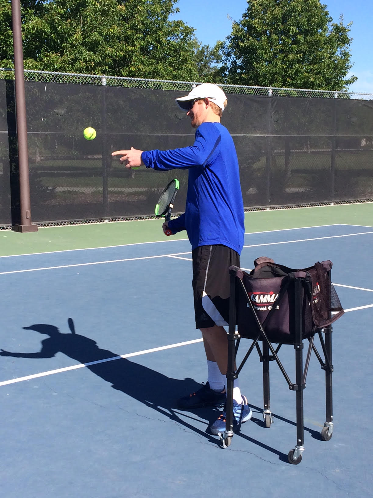 Tennis with Cole instructor hitting tennis ball
